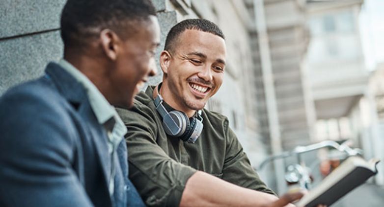 A man encourage his friend to read a book for fast recovery in alcohol addiction