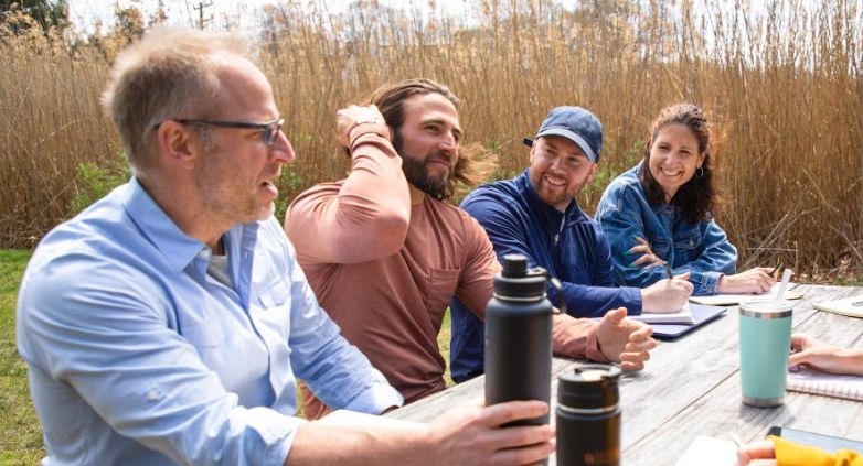 A group of family members gathered around a picnic table, symbolizing support and connection amidst challenges of addiction.