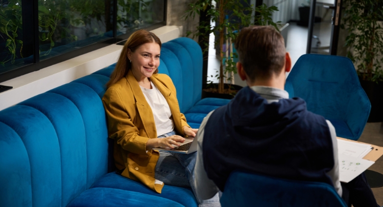 A man and woman seated on a couch in an office, discussing virtual addiction recovery programs by Project Courage.