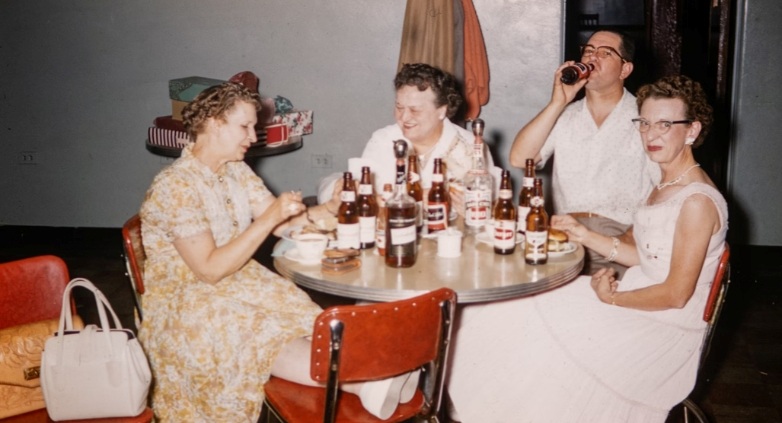 A group of people at a table, enjoying beer, reflecting on family history and the impact of alcoholism.