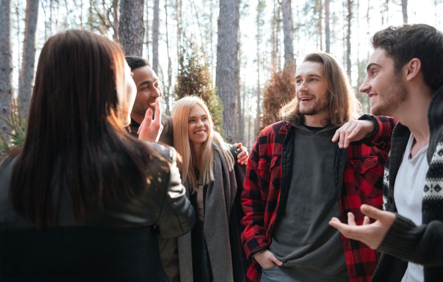 Friends chatting together in a serene forest, symbolizing camaraderie and the importance of community in recovery.