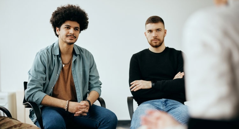 A group therapy session with three men talking, emphasizing a unique approach to overcoming drug addiction challenges.