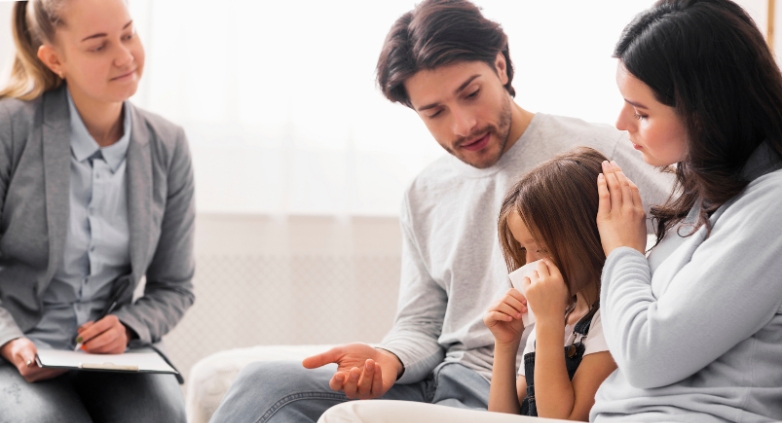 A family with psychiatrist, sits on a couch, emphasizing the need for support for children of alcoholic parents.