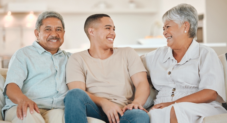 A family sitting on a couch, illustrating unity and support in a discussion about addiction and enabling behaviors.