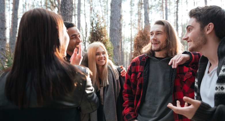 Young individuals conversing in the woods, focusing on managing relationships and social settings in addiction recovery.