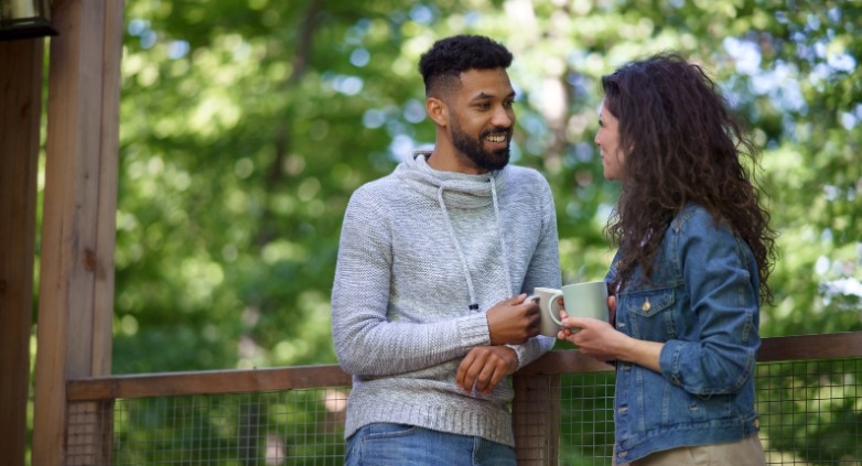 A couple engage in conversation on a porch, focusing on how to help an alcoholic husband without enabling.