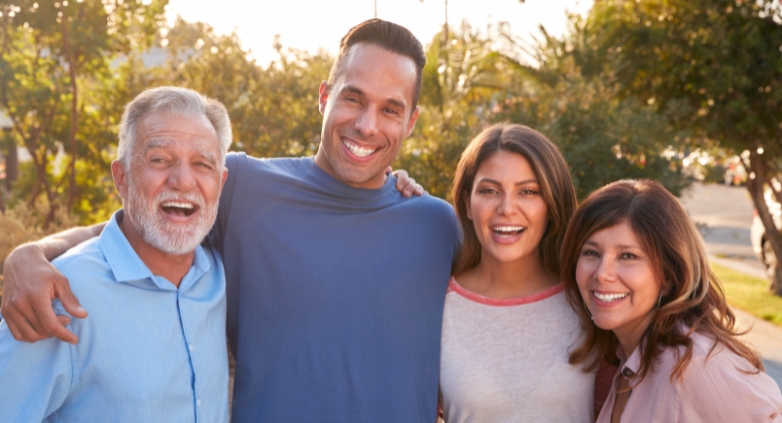 A joyful family of four, smiling, symbolizing hope and connection in the context of addiction treatment therapy.
