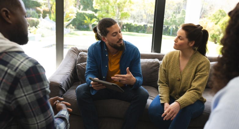 A group of people converse with a group about navigating family dynamics and social pressure while staying sober during holidays.