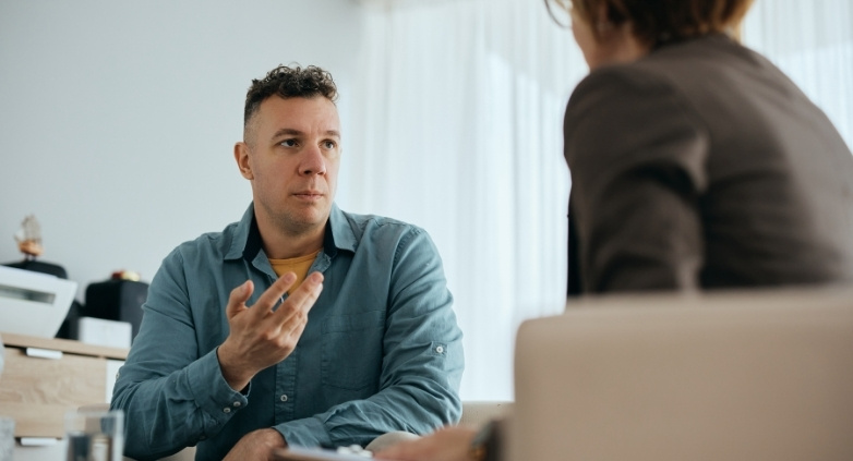 A man and woman engage in conversation in an office, focusing on mindful drinking strategies for the holiday period.