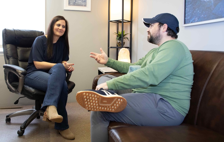 A man and woman converse on a couch, focusing on issues surrounding methamphetamine addiction treatment in Connecticut.