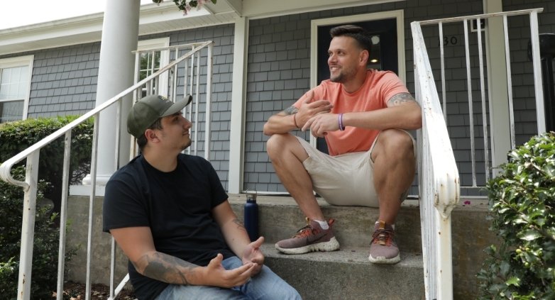 Two men on the steps of a house, sharing insights on how to stay sober during the festive holiday period.