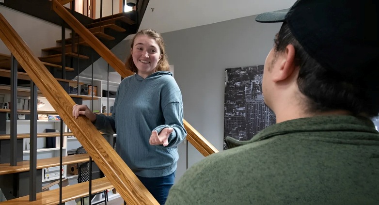 A woman and a man standing on a staircase, illustrating the connection fostered in support groups for families of addicts.