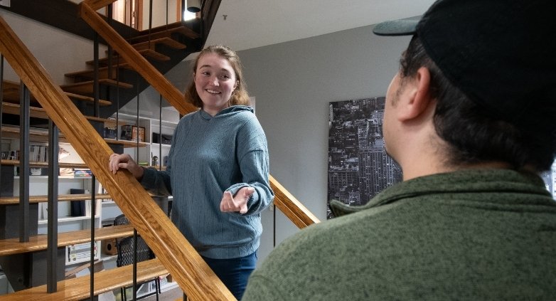 A woman and a man standing on a staircase, illustrating the theme of family support in addiction recovery efforts.