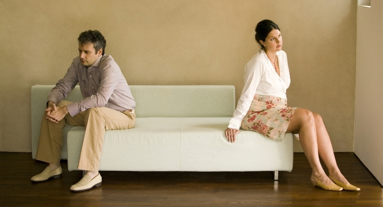 A man and woman are seated on a couch, contemplating their marriage and the boundaries necessary due to alcoholism.