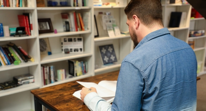 Man reviewing educational materials, learning how to support an alcoholic family member through understanding addiction as a disease.