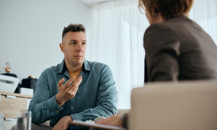 Man speaking to woman in office about Intensive Outpatient Alcohol Therapy.