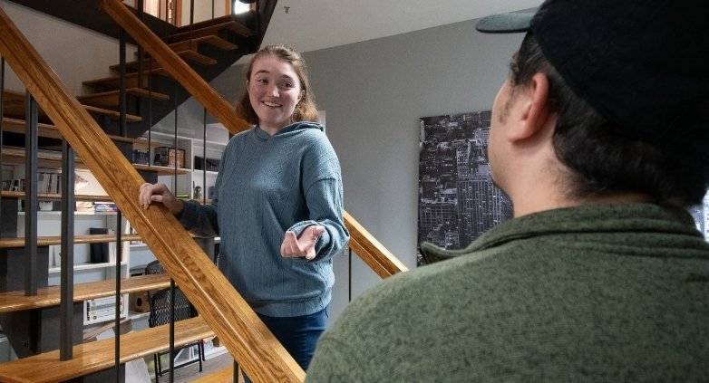 A woman and a man stand on the stairs of a house, addressing common challenges for families of alcoholics.