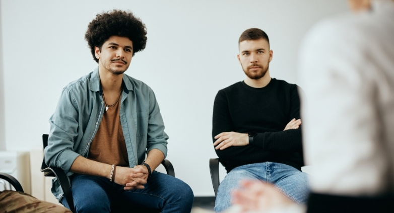 Group of people seated in a room, conversing about finding support in a counseling session for families of alcoholics.