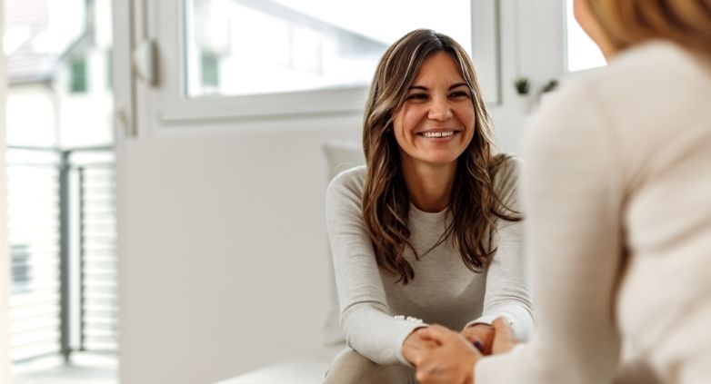 A woman converses with another, focusing on the role of forgiveness in the journey of addiction recovery.