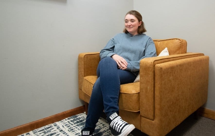 Teen in outpatient addiction treatment sitting in counseling office
