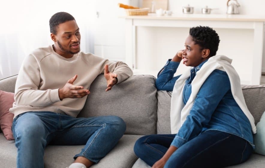 Two people having a conversation during drug addiction recovery in a comfortable home setting