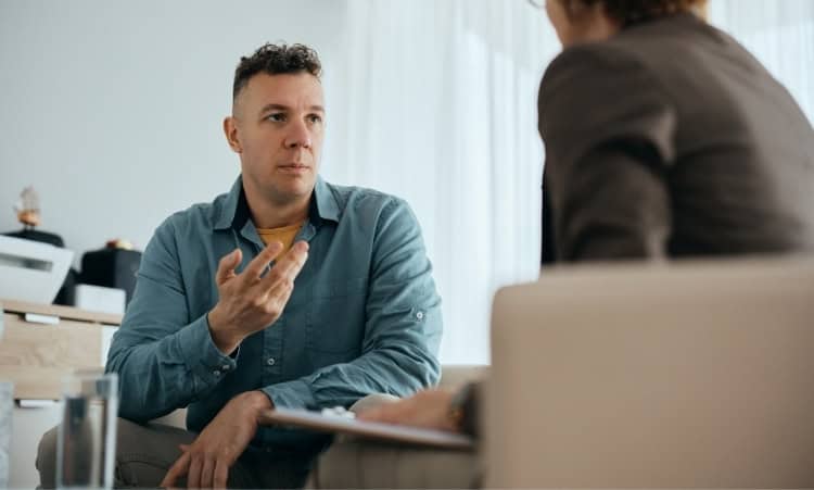 Man participating in intensive outpatient therapy for drug addiction recovery with a counselor