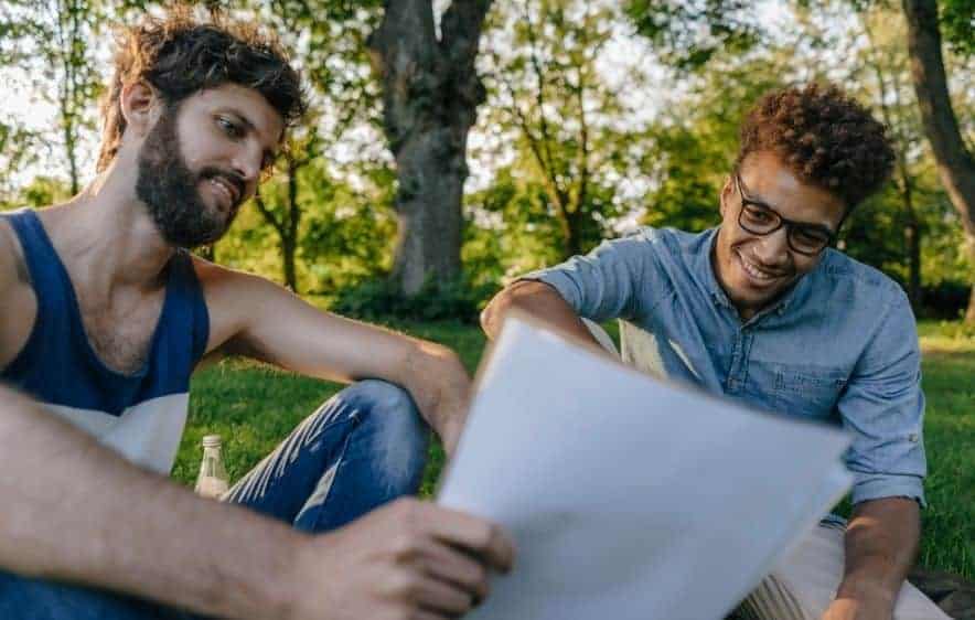 Two men reviewing addiction recovery materials outdoors in Essex, CT